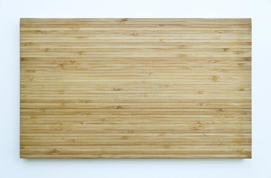 Bamboo cutting board on light blue background