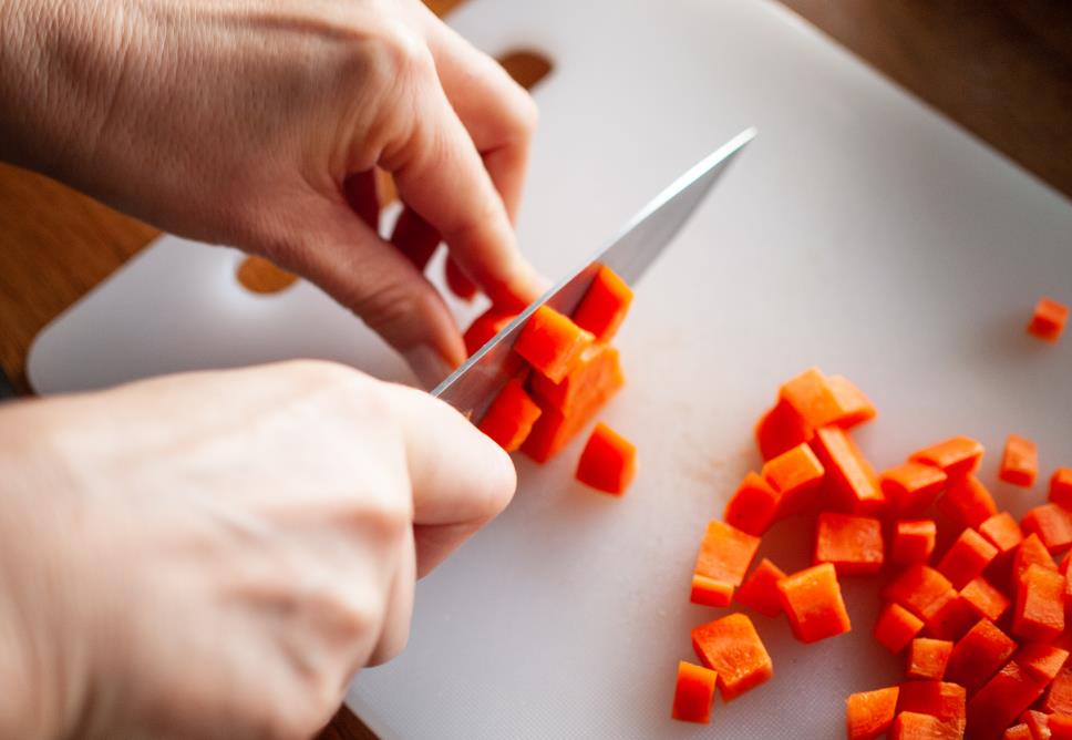 Cutting carrots on plastic cutting board