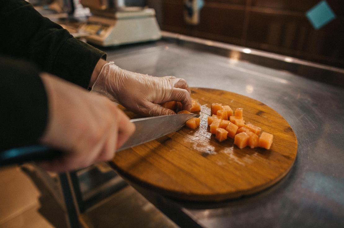 cutting fish on a round wooden cutting board