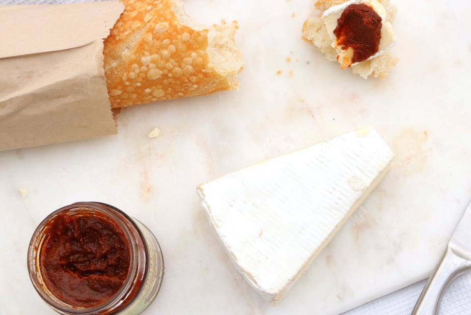 cheese slice, bread, and jams on top of marble cutting boards