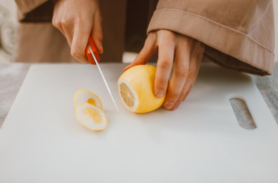 chef cutting lemons on a plastic cutting board