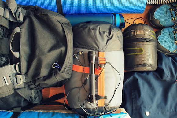 Flat lay composition with camping equipment on wooden background